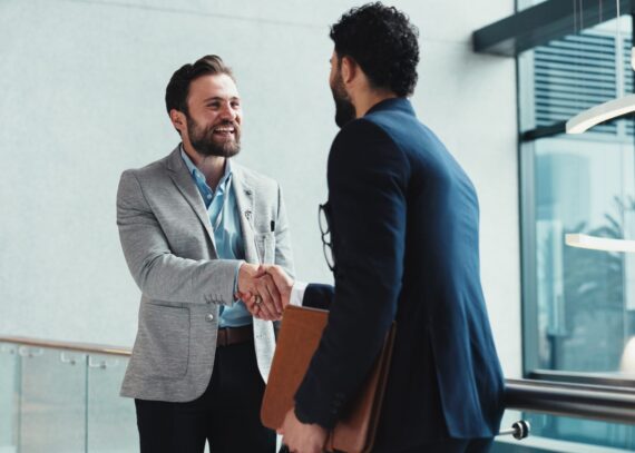 Accountmanager in technische B2B schudt de hand van een klant bij het sluiten van een deal en het versterken van de samenwerking