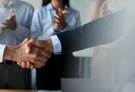 Ferme maar coöperatieve handdruk bij het afronden van een onderhandeling, symbool voor sterke deals en duurzame samenwerking in B2B